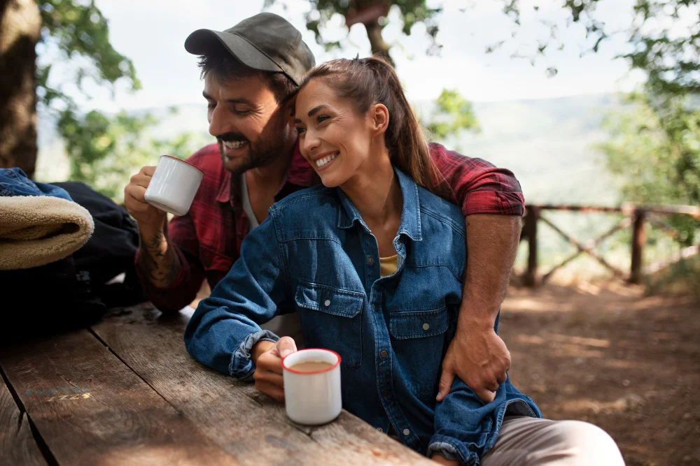 Pareja feliz tomando cafe en el bosque