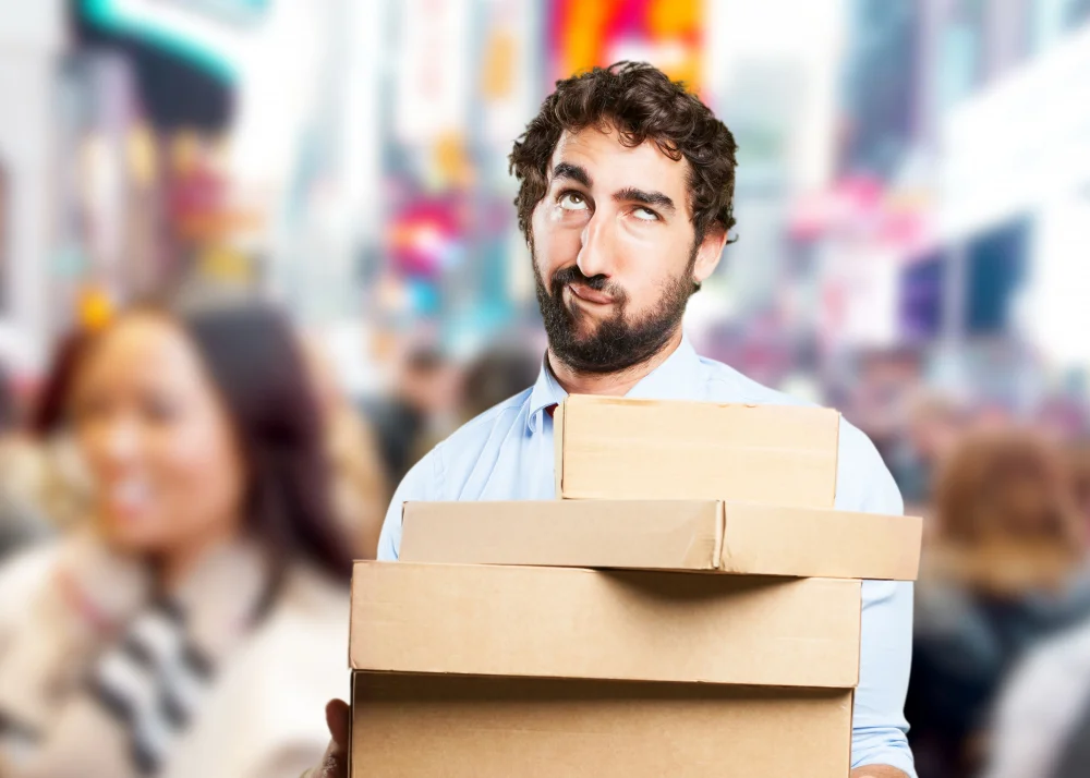 hombre haciendo muecas y sosteniendo cajas