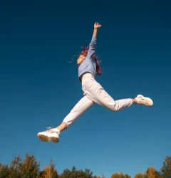 mujer haciendo un salto con los pies abiertos