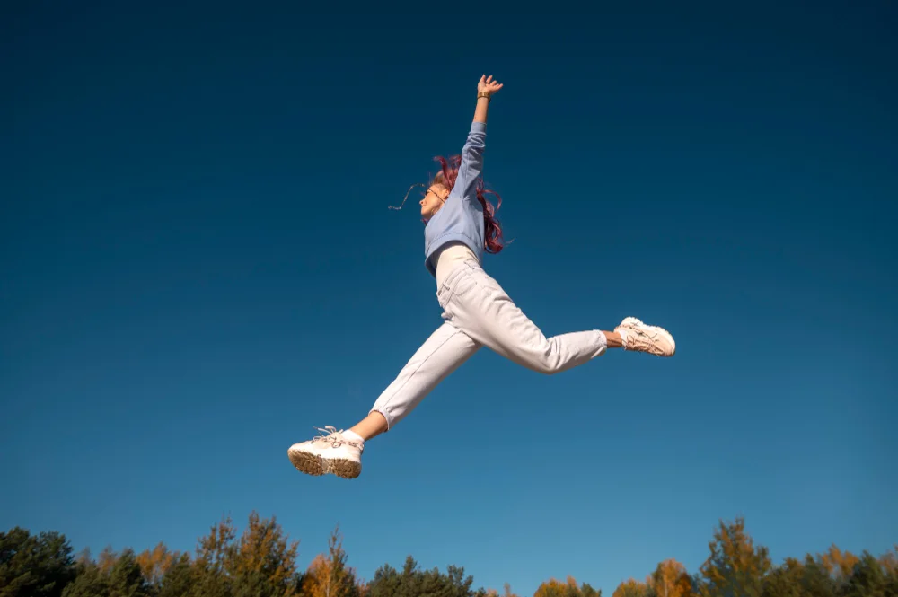 mujer haciendo un salto con los pies abiertos